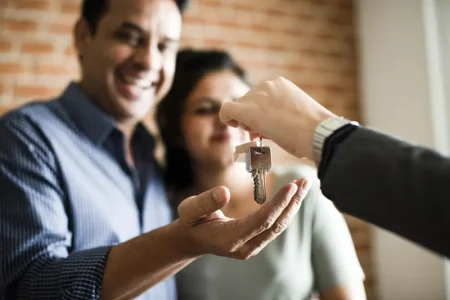 cheerful-couple-with-keys-their-new-home