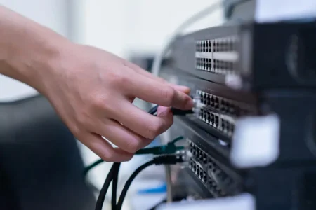 engineering-woman-hand-trying-connecting-lan-switch-layer-2-sharing-file-networking